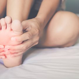 health care concept. woman massaging her painful foot red hi-lighted on pain area